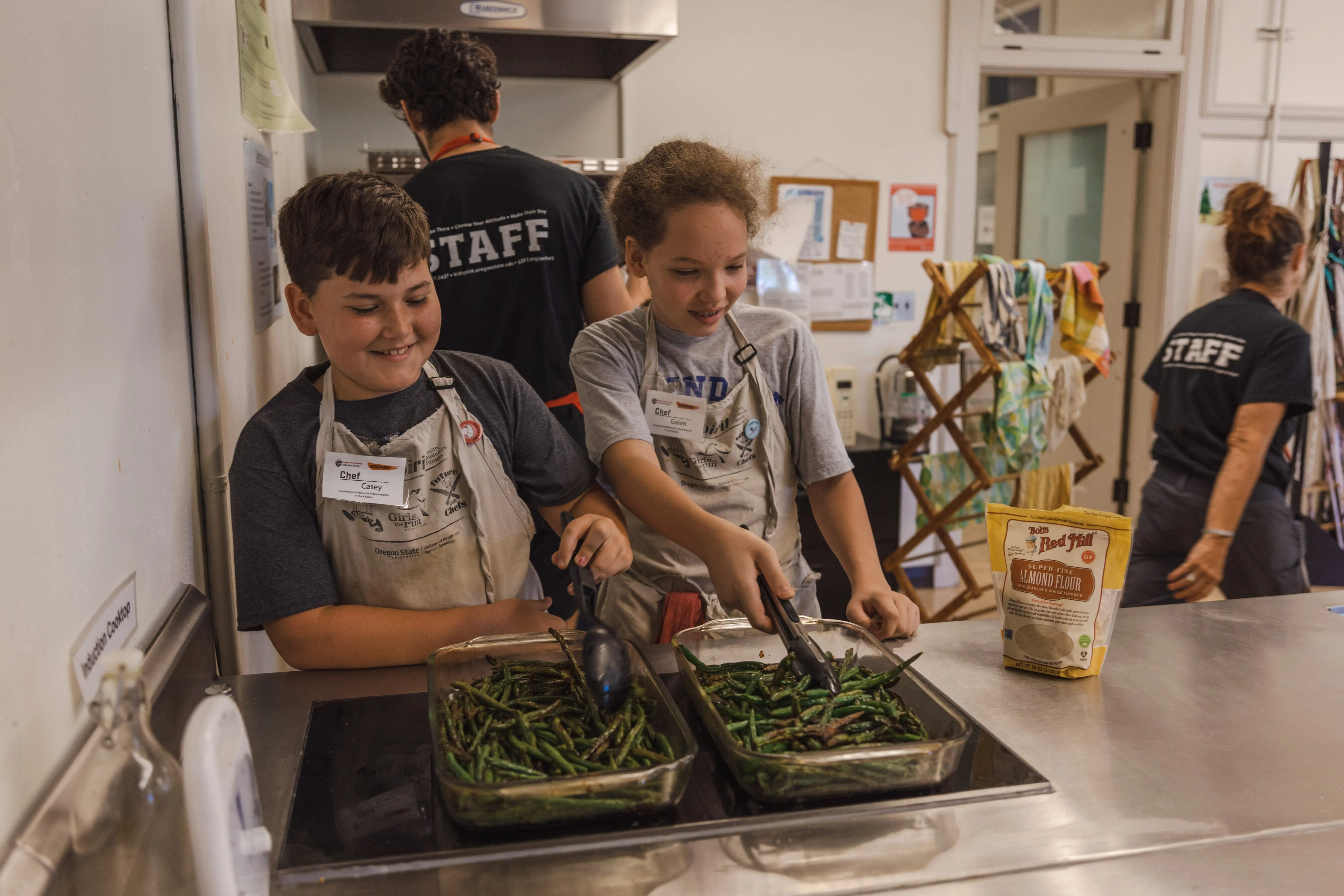 Campers serving asparagus and smiling